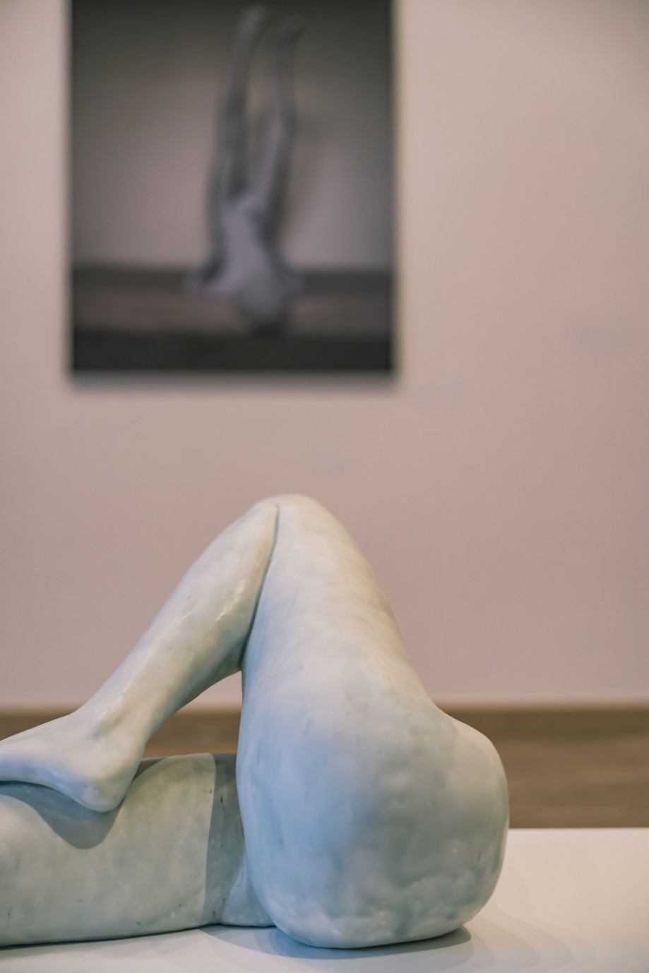 Sculptuur van gekruiste benen in een tentoonstellingsruimte