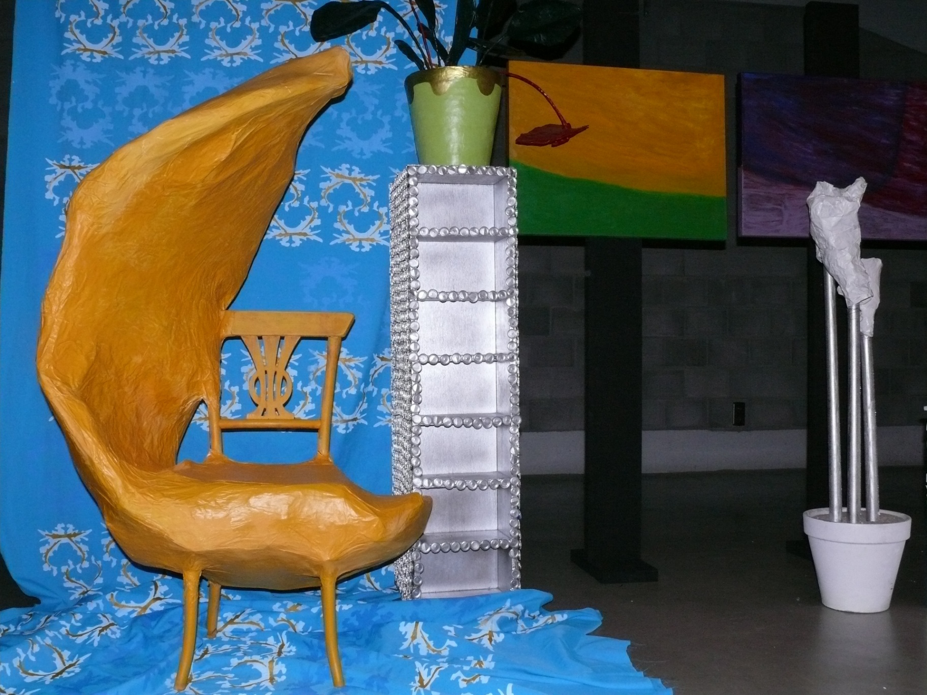 Sculpturale installatie met gele stoel en blauw doek