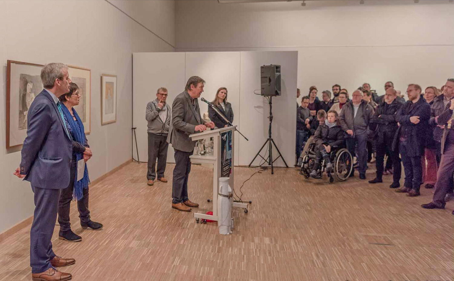 Publiek bij de opening in een tentoonstellingsruimte