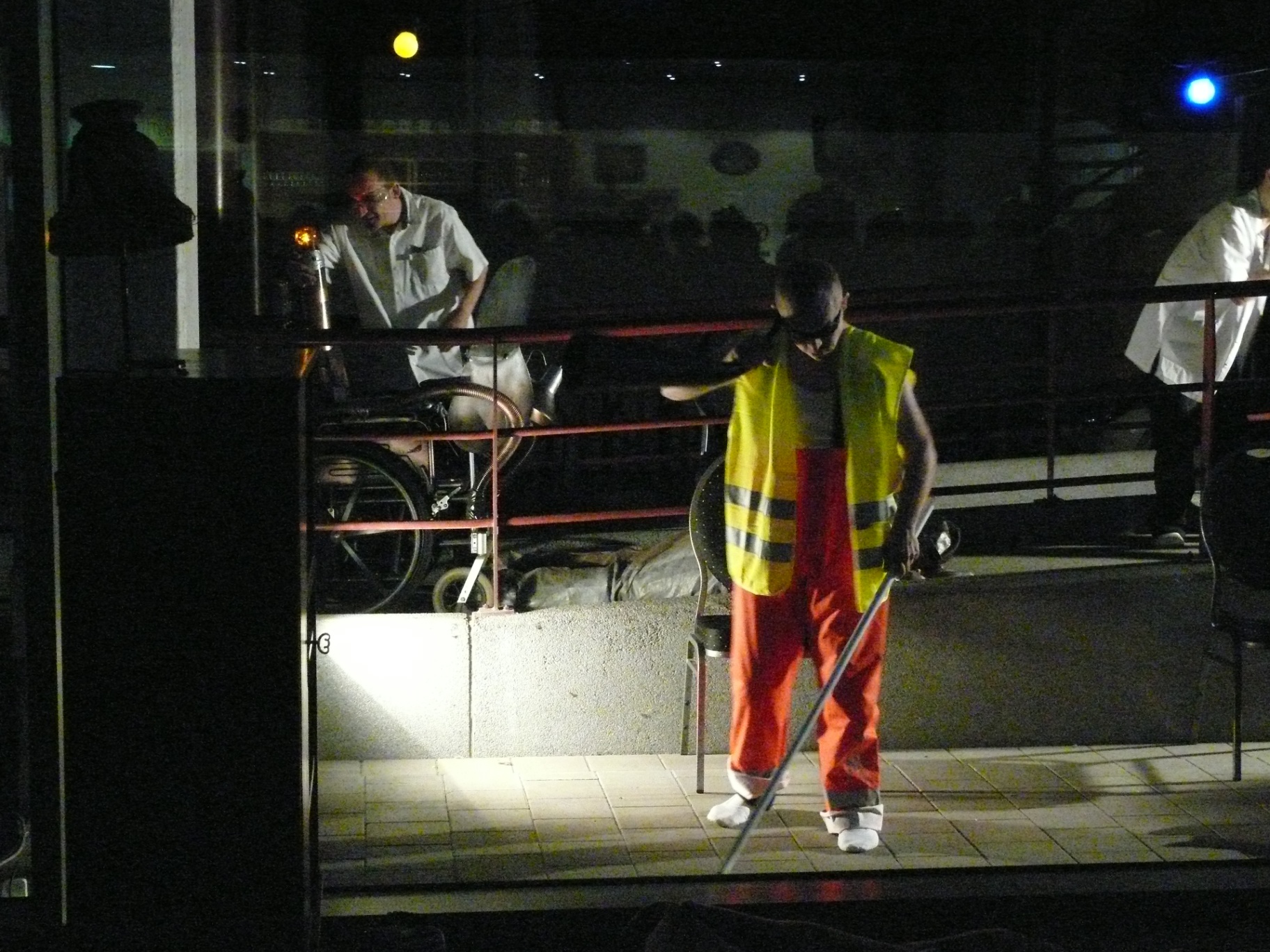 Performer met vest en bezem op scène