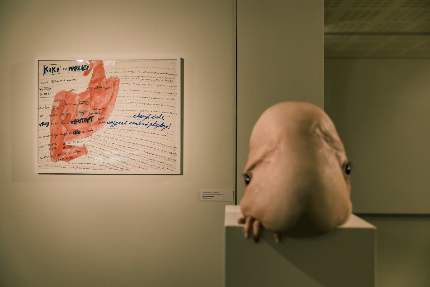 Tekening 'Kiki en Marlies' naast een sculptuur van een hoofd