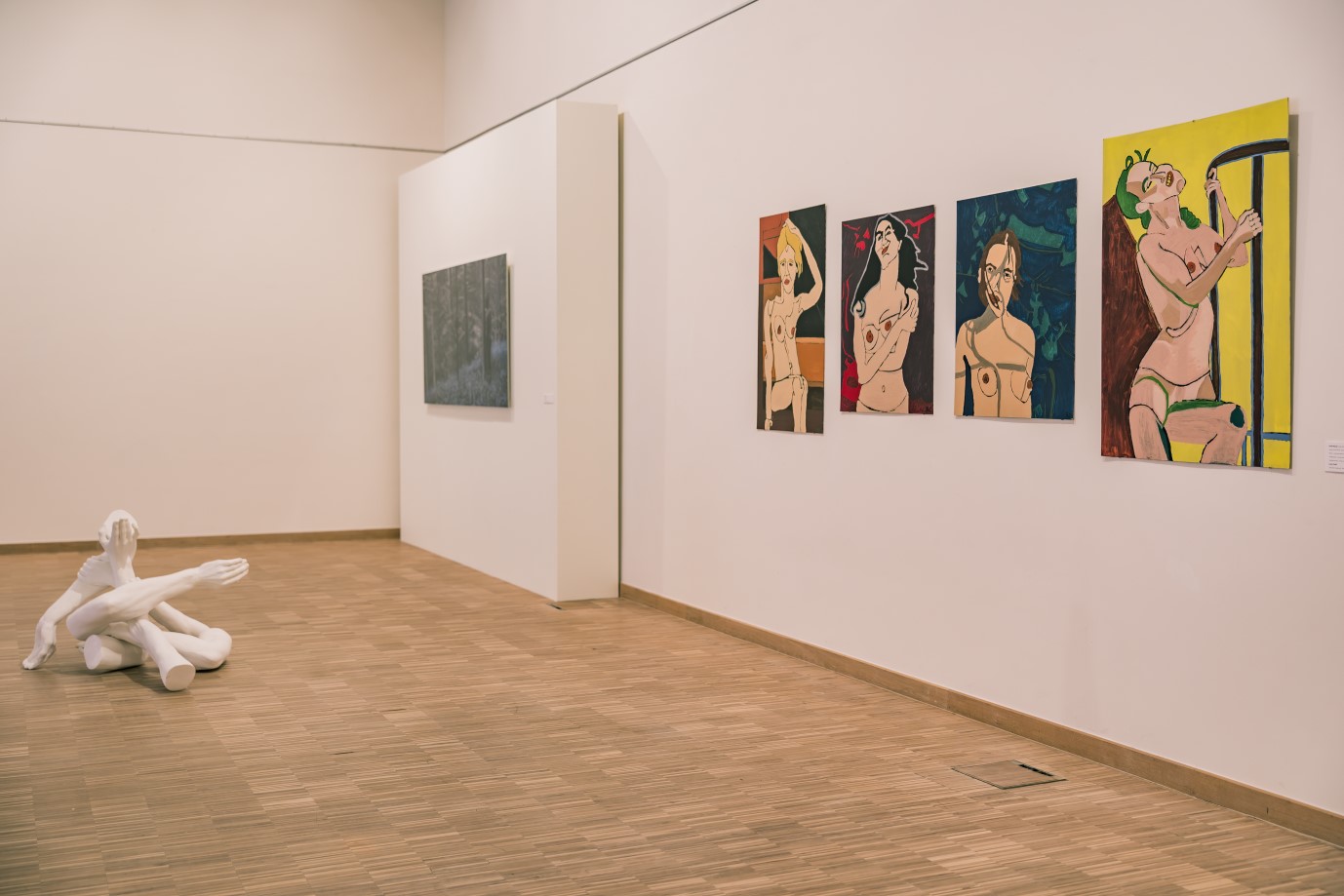 Zaalzicht met vier kleurrijke portretten en een witte sculptuur op de vloer