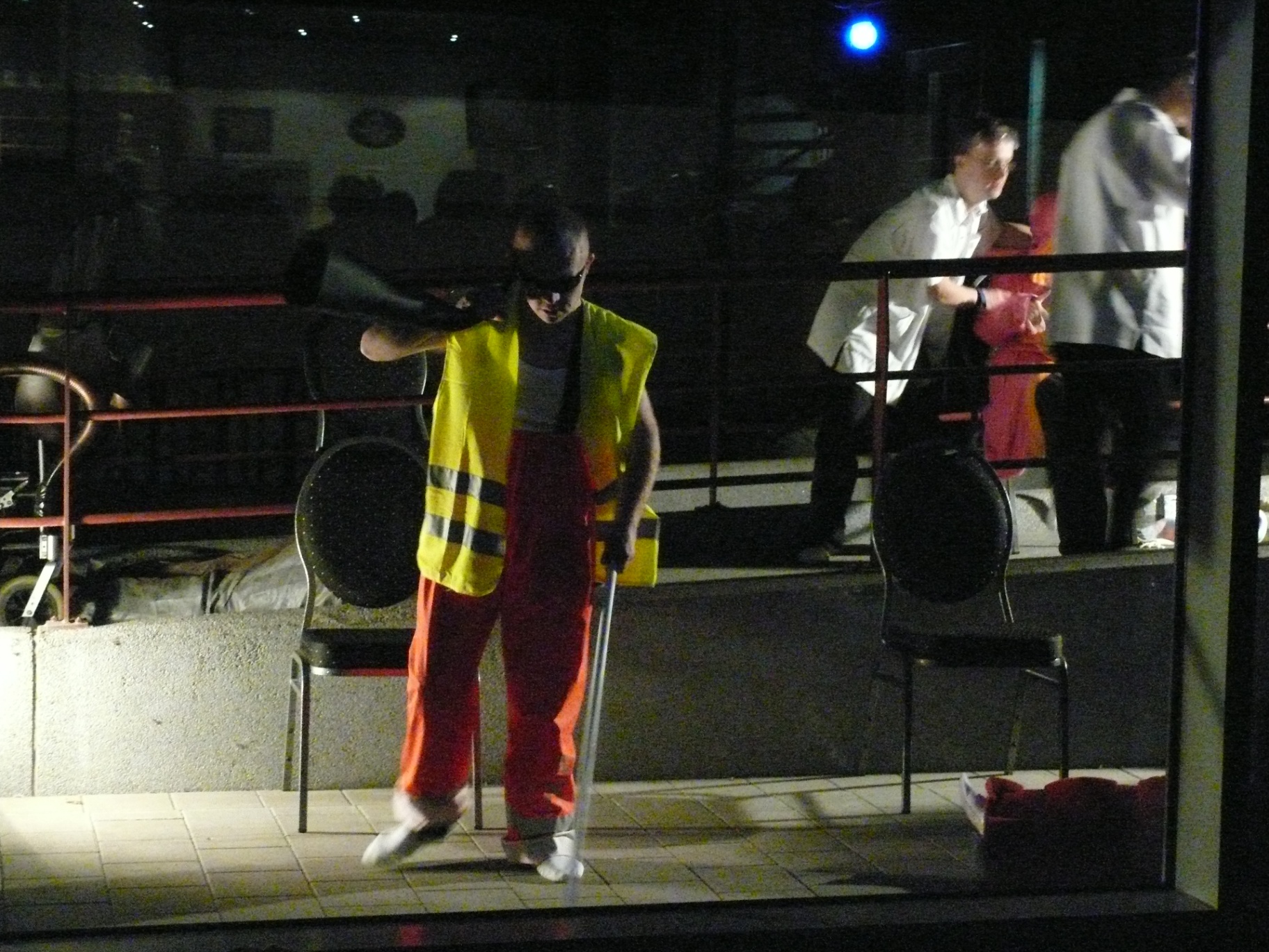 Performer in oranje broek en fluogeel vest