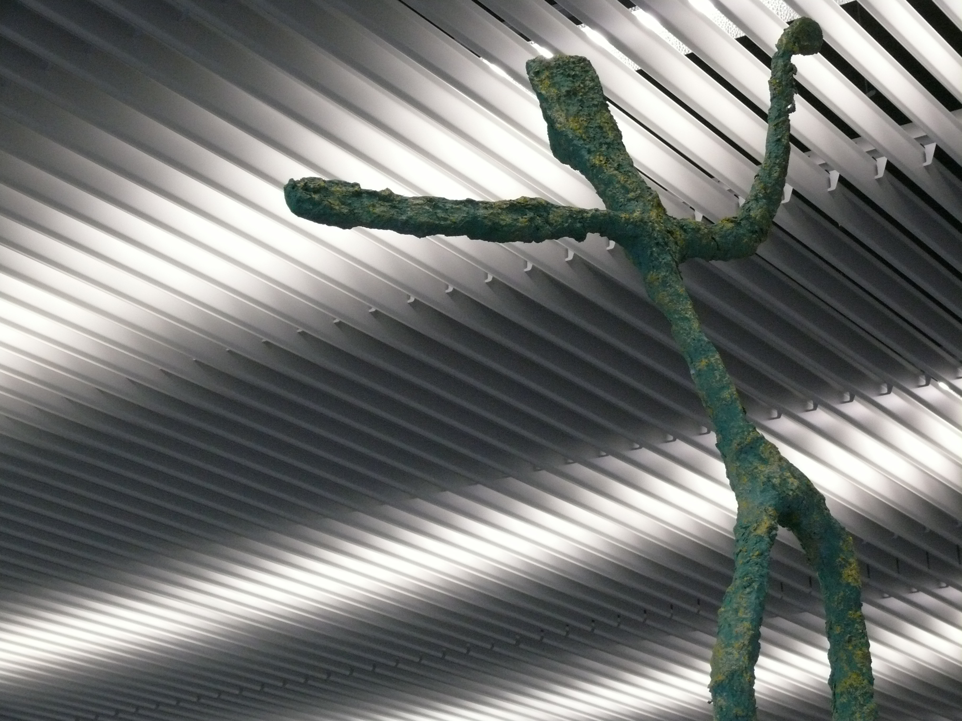 Groene sculptuur van een figuur met opgeheven armen
