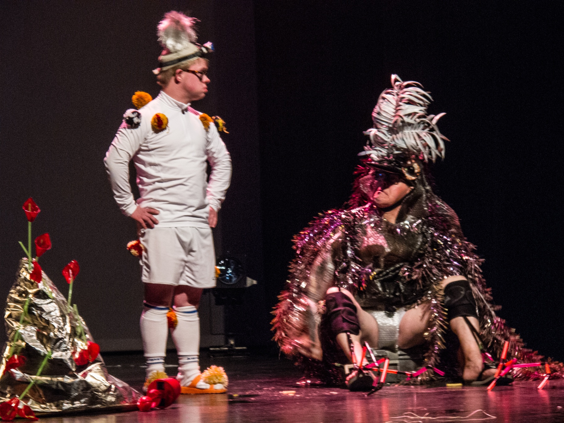 Twee performers in feestelijke kostuums op een donker podium