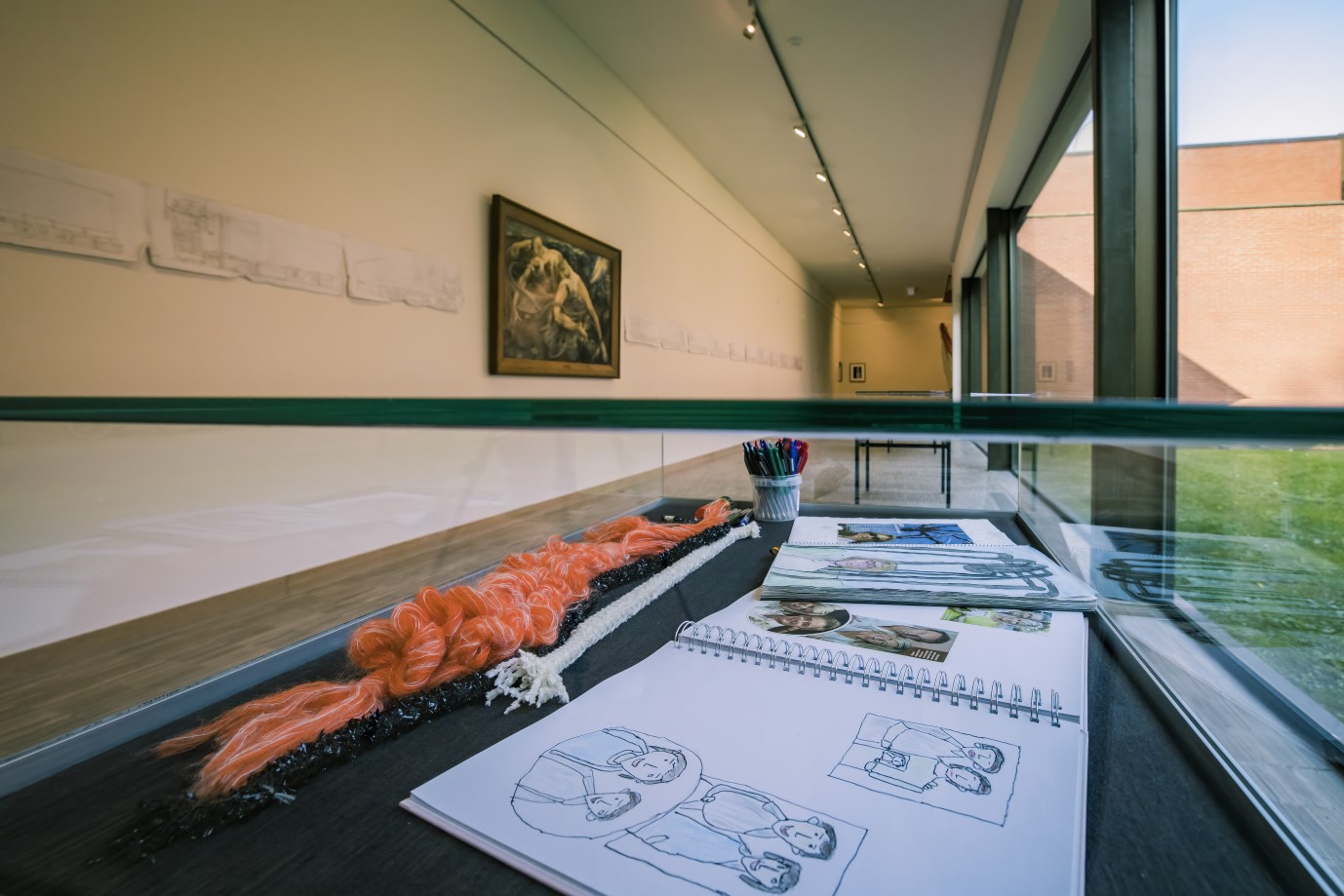 Vitrine met haarwerk en schetsboeken naast raampartij