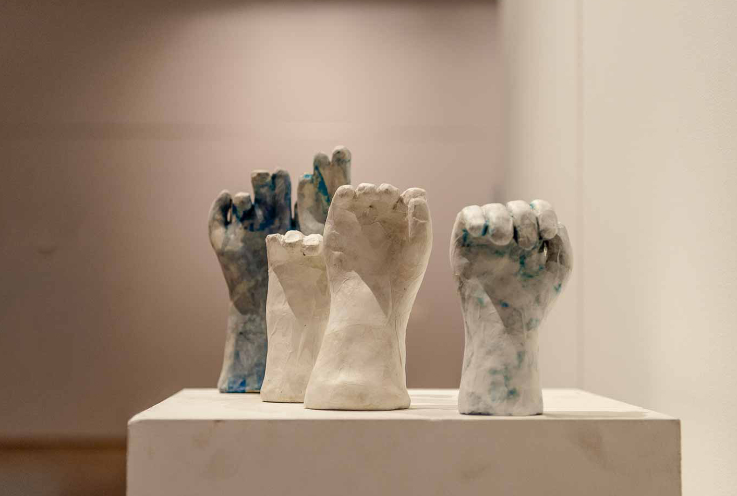Vuistsculpturen in wit en blauw op een sokkel